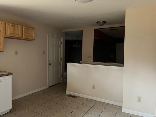 kitchen with light tile patterned floors, dishwasher, and light brown cabinets