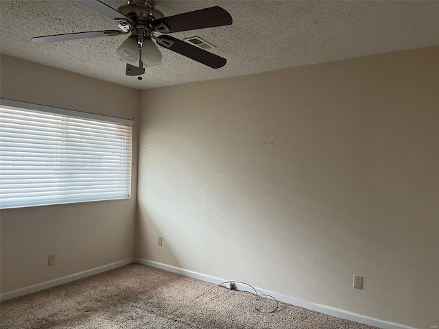 unfurnished room with ceiling fan, carpet flooring, and a textured ceiling