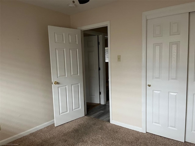 unfurnished bedroom with dark colored carpet