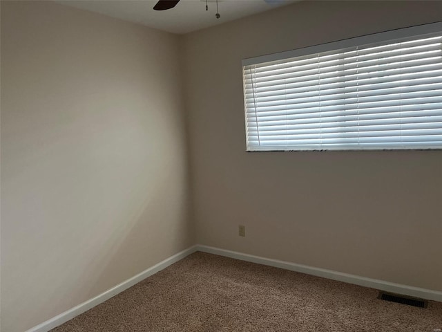 empty room featuring ceiling fan and carpet