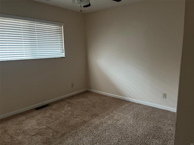 carpeted spare room with ceiling fan