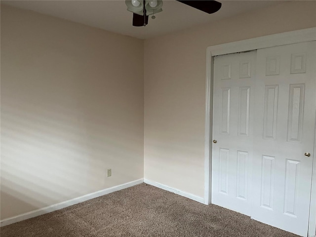 unfurnished bedroom with ceiling fan, carpet flooring, and a closet