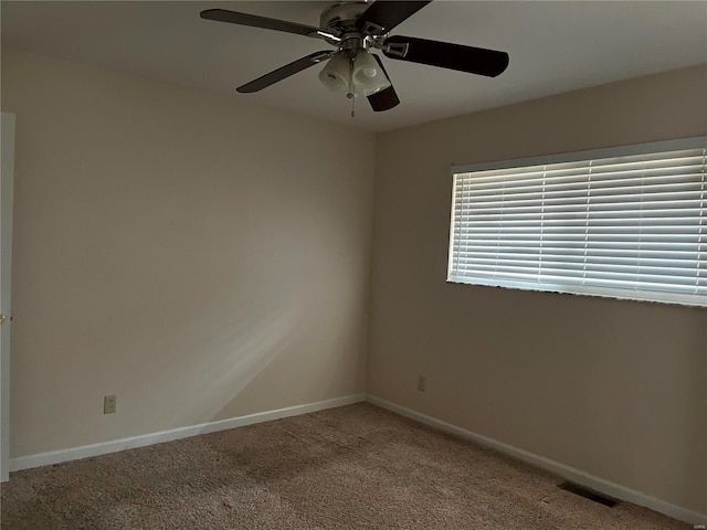 spare room with ceiling fan and carpet