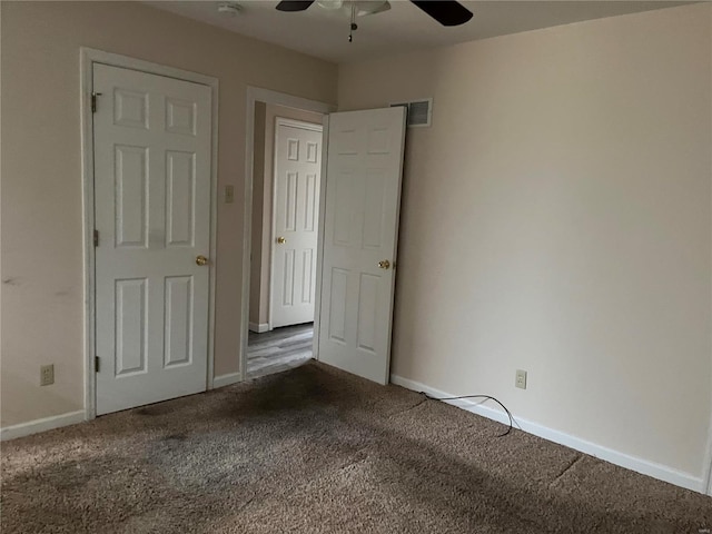 unfurnished bedroom with dark carpet and ceiling fan