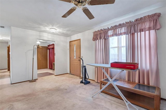 workout room with ceiling fan and carpet