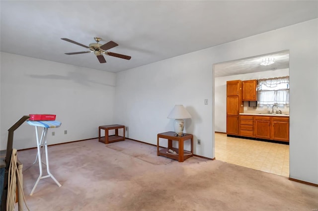 miscellaneous room with sink, light colored carpet, and ceiling fan