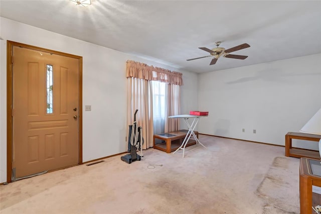 carpeted foyer entrance featuring ceiling fan