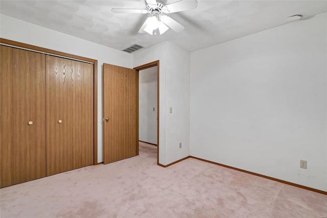 unfurnished bedroom featuring light colored carpet, a closet, and ceiling fan