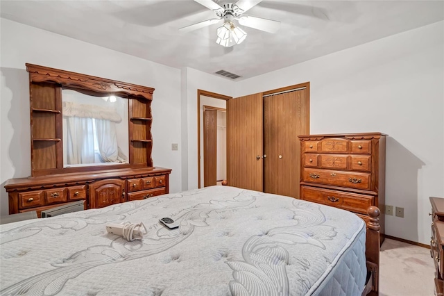 carpeted bedroom with ceiling fan and a closet