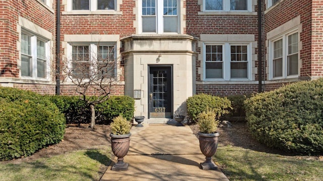 entrance to property featuring brick siding