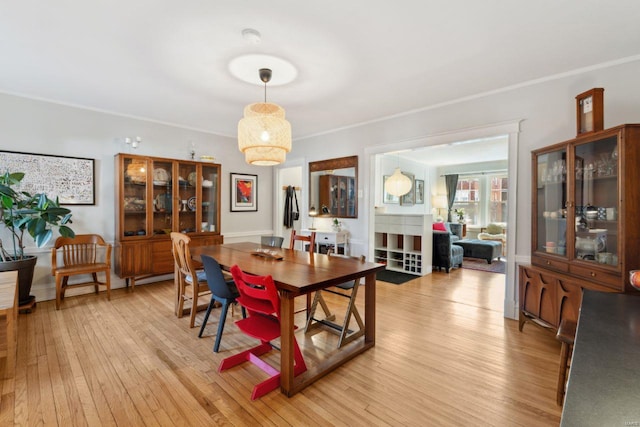 dining area featuring light wood finished floors and baseboards