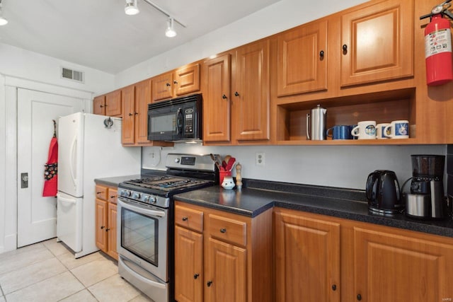 kitchen with black microwave, light tile patterned floors, stainless steel gas range oven, visible vents, and open shelves