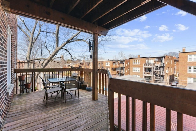 wooden terrace with a residential view and outdoor dining area