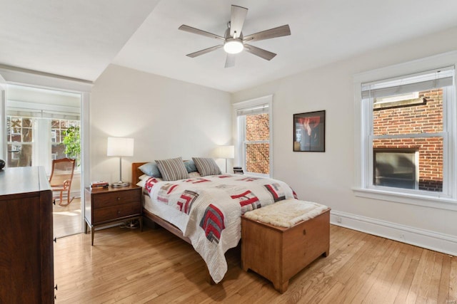 bedroom featuring light wood-style flooring, baseboards, and ceiling fan