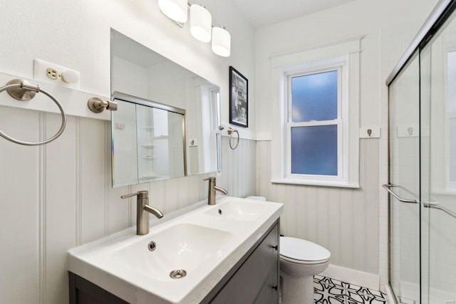 bathroom featuring double vanity, a shower stall, and a sink