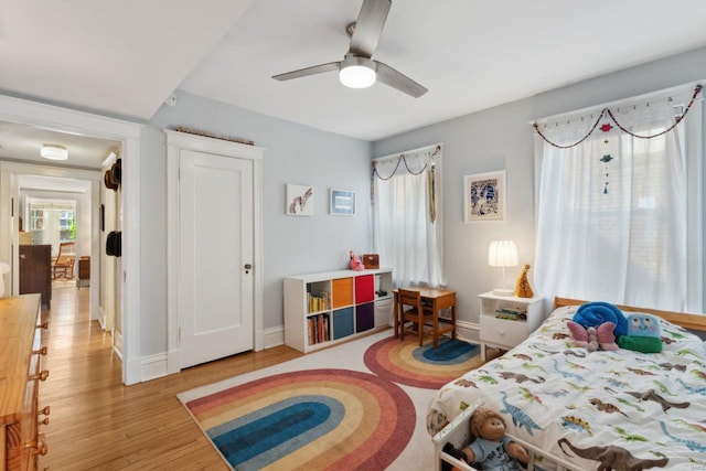 bedroom featuring a ceiling fan, baseboards, and wood finished floors