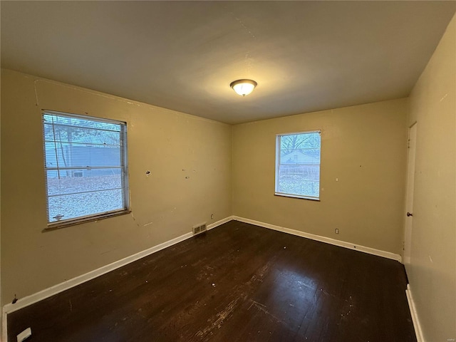 empty room with dark hardwood / wood-style flooring