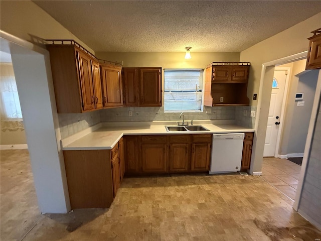 kitchen featuring sink, backsplash, a textured ceiling, and dishwasher