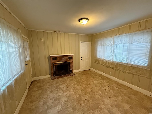 unfurnished living room featuring ornamental molding, a brick fireplace, and a wealth of natural light