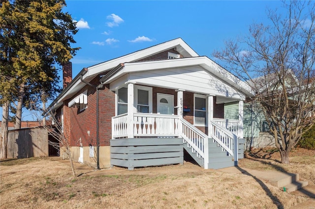 bungalow-style home with a porch and a front lawn