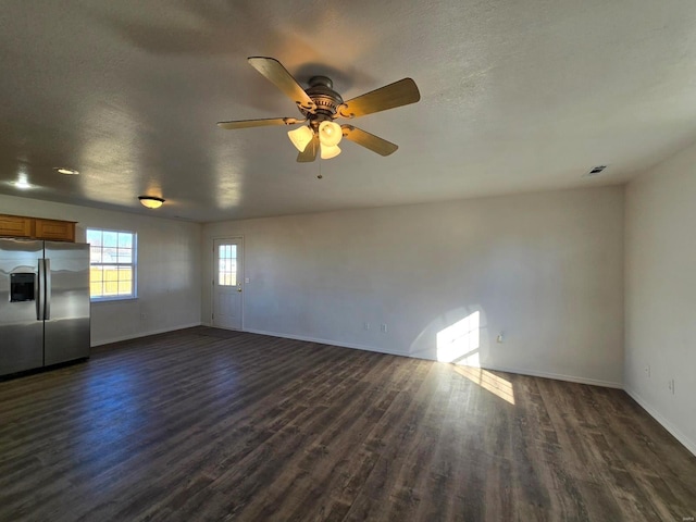 unfurnished living room featuring ceiling fan, dark hardwood / wood-style floors, and a textured ceiling