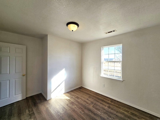 unfurnished room featuring dark hardwood / wood-style floors and a textured ceiling