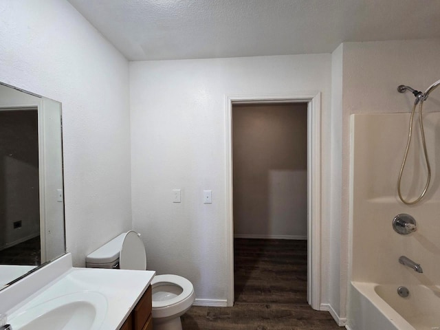 full bathroom with toilet, wood-type flooring, shower / bathing tub combination, a textured ceiling, and vanity