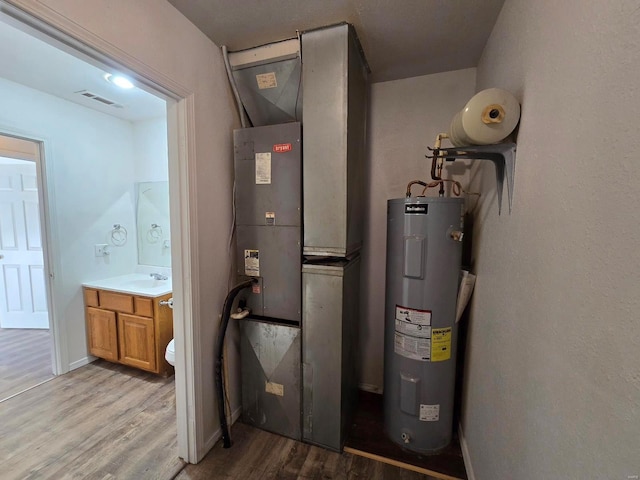 utility room with water heater, sink, and heating unit