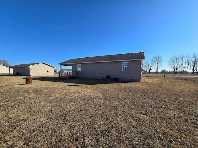 back of property with a wooden deck and a yard