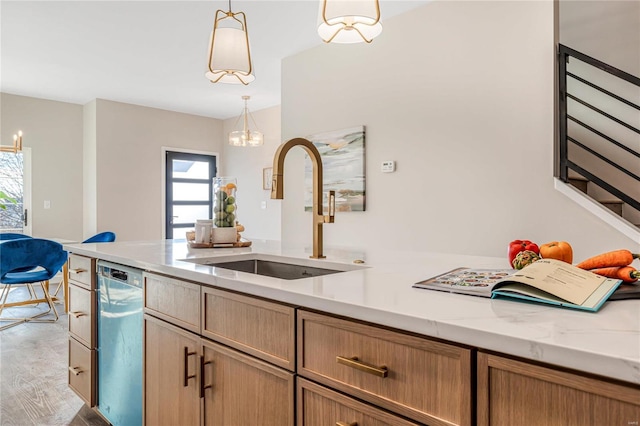 kitchen featuring dishwashing machine, sink, decorative light fixtures, and light stone countertops