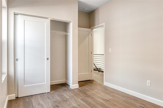 unfurnished bedroom featuring a closet and light wood-type flooring