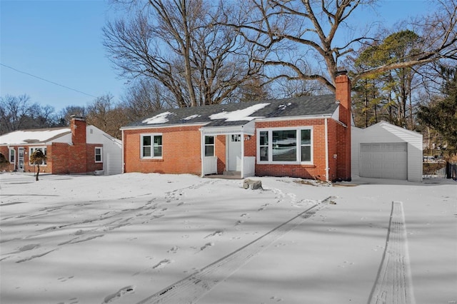 view of front of house with an attached garage, a chimney, and brick siding