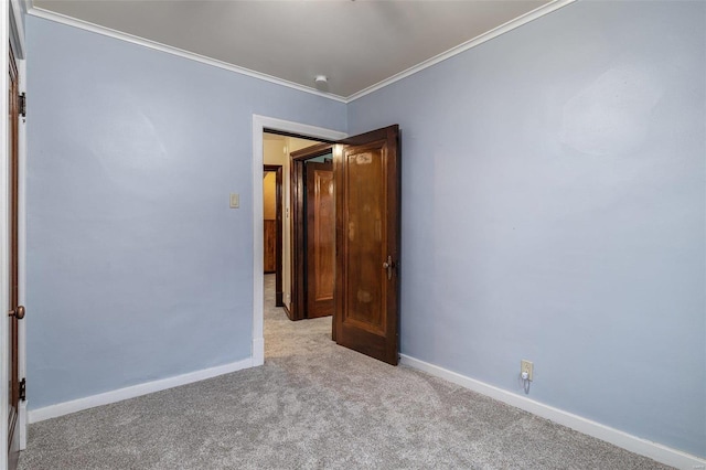 carpeted spare room featuring crown molding