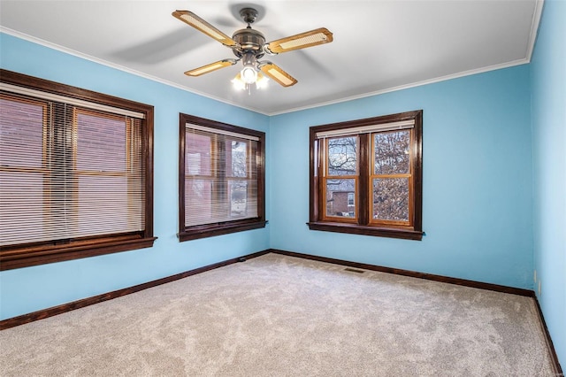 unfurnished room with crown molding, light colored carpet, and ceiling fan