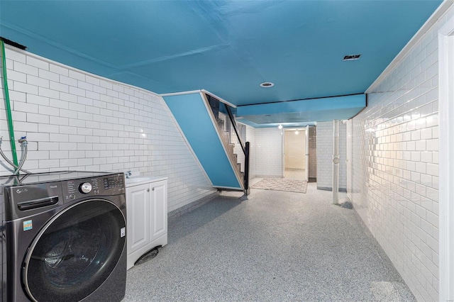 laundry area with tile walls, washer / clothes dryer, sink, and cabinets