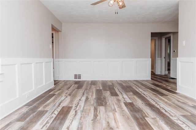 unfurnished room with ceiling fan, hardwood / wood-style floors, and a textured ceiling