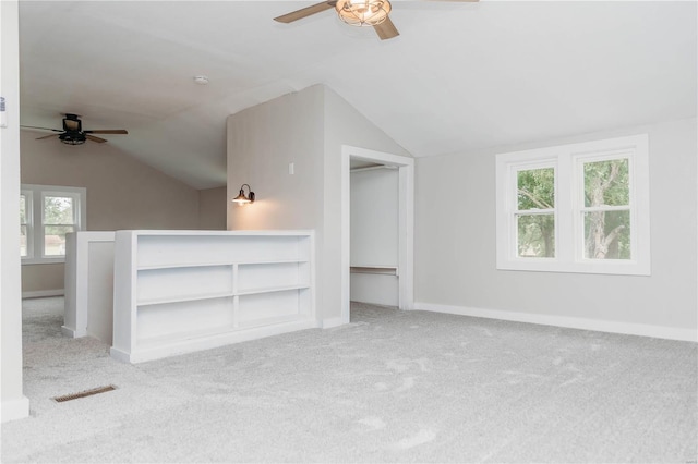 additional living space with ceiling fan, light colored carpet, and vaulted ceiling