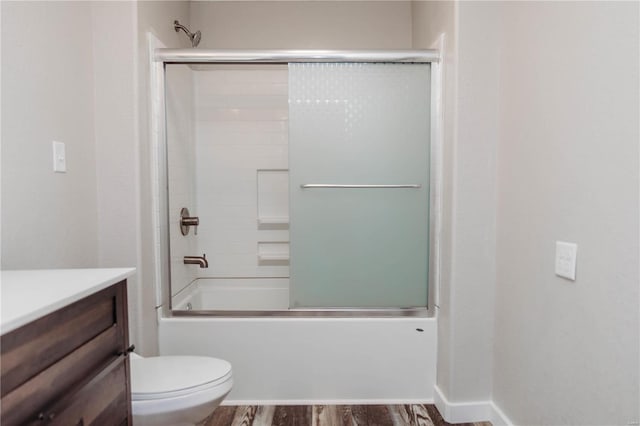 full bathroom featuring toilet, vanity, shower / bath combination with glass door, and hardwood / wood-style floors