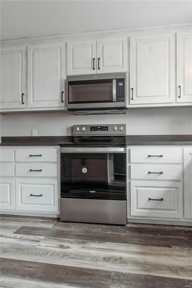 kitchen featuring wood-type flooring, stainless steel appliances, and white cabinets