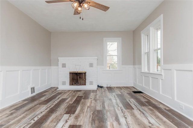 unfurnished living room featuring hardwood / wood-style flooring, a fireplace, and ceiling fan