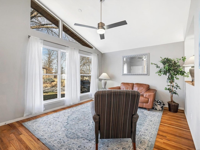 living room featuring wood-type flooring, ceiling fan, and vaulted ceiling