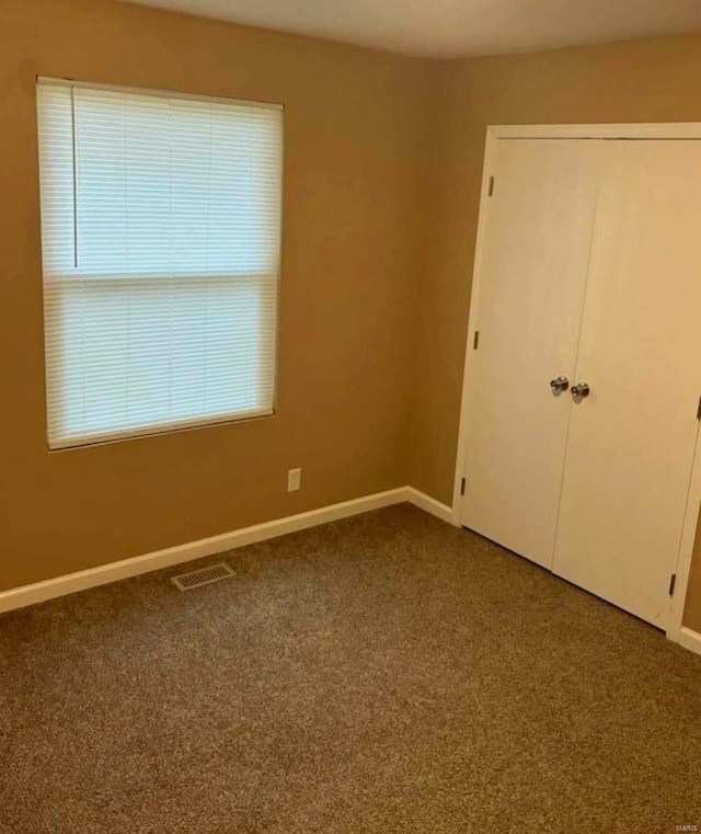 unfurnished bedroom with carpet floors and a closet