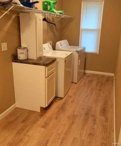 clothes washing area featuring light hardwood / wood-style flooring and washing machine and dryer