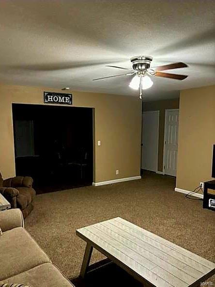 carpeted living room with ceiling fan and a textured ceiling