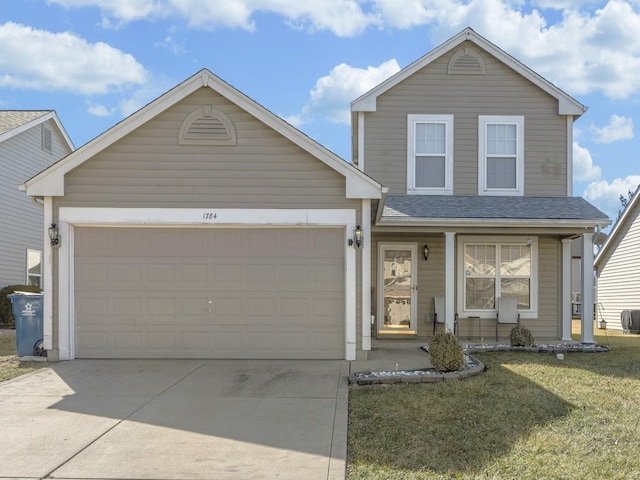 traditional home featuring an attached garage, covered porch, driveway, and a front lawn