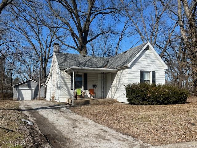 view of front of home with a garage, an outdoor structure, and a porch