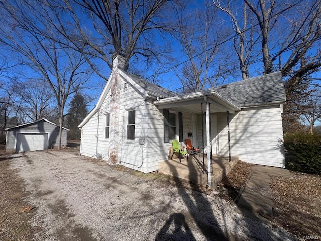 view of front of house with a garage, an outdoor structure, and covered porch