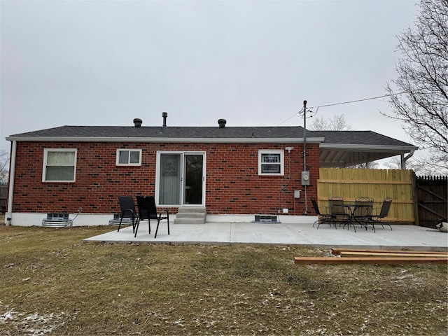 back of house with a patio area and a lawn