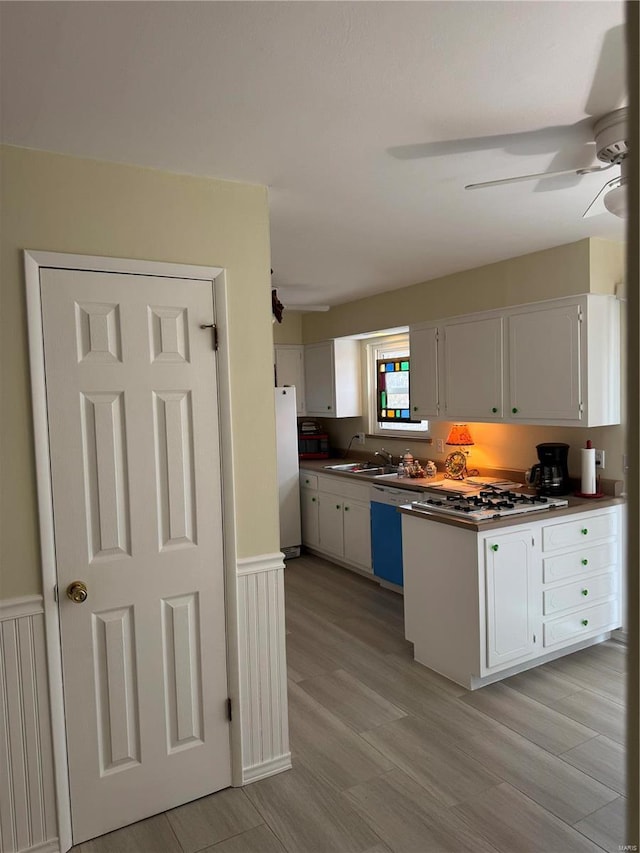 kitchen with gas stovetop, white cabinetry, light hardwood / wood-style flooring, white refrigerator, and dishwasher