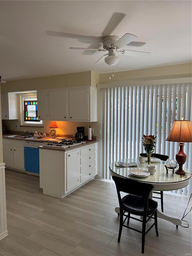 kitchen with stainless steel gas stovetop, dishwasher, sink, and white cabinets